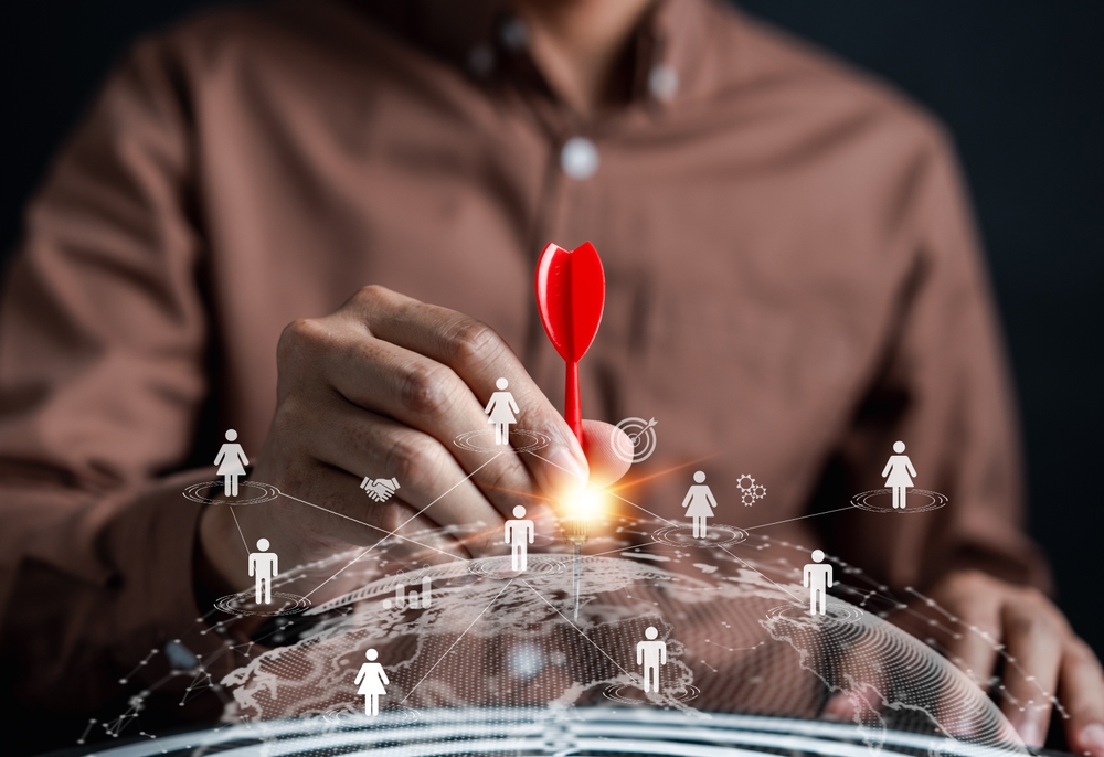 Osoba postavlja cilj na digitalnoj mapi korisnika, simbolizujući izazove u preciznom merenju i targetiranju kod promotivnih proizvoda